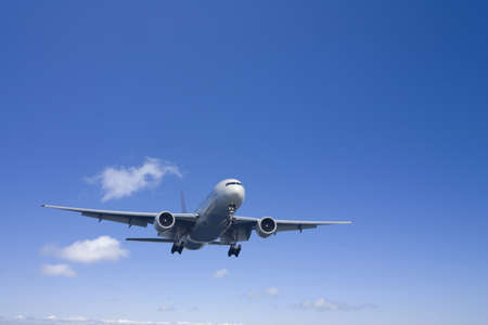 An airplane flying in the blue skyの写真素材
