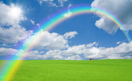Green grass and red roof house and rainbow の写真素材
