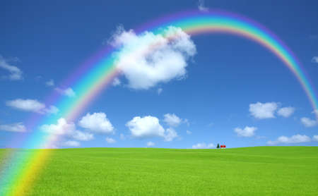 Green grass and red roof house and rainbowの写真素材