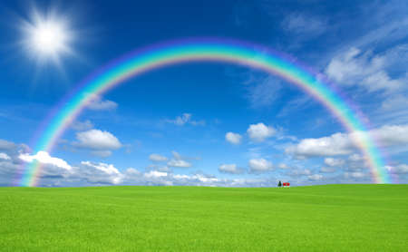 Green grass and red roof house and rainbowの写真素材