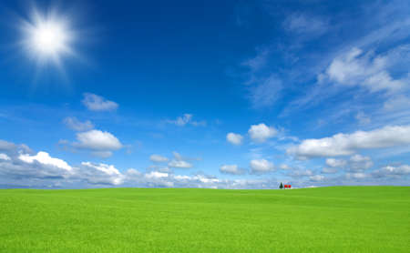 Green grass and red roof house and rainbow の写真素材