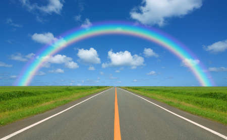 Rainbow over straight roadの写真素材