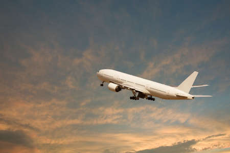 An airplane flying in the orange skyの写真素材