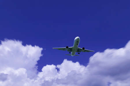 An airplane flying in the blue skyの写真素材
