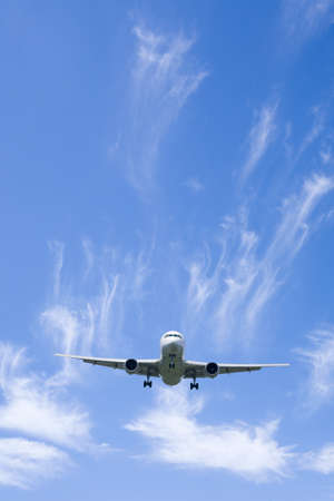 An airplane flying in the blue skyの写真素材