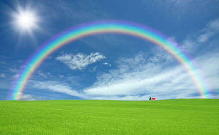 Green grass and red roof house and rainbow の写真素材