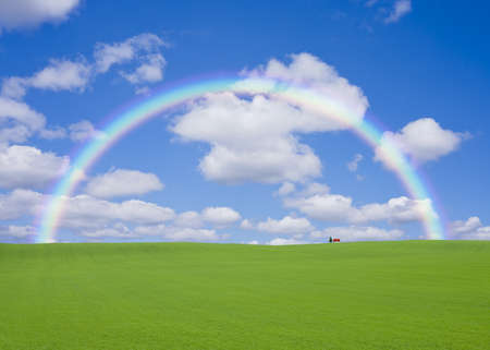 Red roof house on the hill with rainbowの写真素材