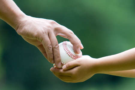 Dad pass the ball to son.の写真素材
