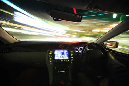 A behind the steering wheel view of lights when driving at night showing movement blur.のeditorial素材