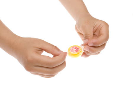 Unwrapping a candy with hands on white backgroundの写真素材