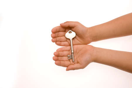 Key lying across the palms of cupped hands, overhead view.の写真素材
