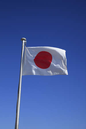 Closeup of a Japanese flag with blue sky の写真素材