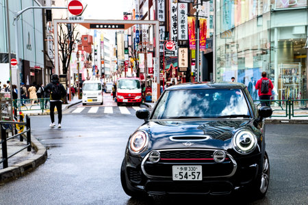 Tokyo, Japan - March 29, 2024: Mini Cooper S is captured driving through the heart of Shinjuku,...