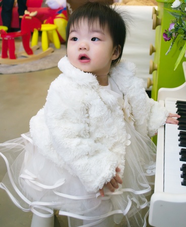 A baby playing on a toy pianoの写真素材