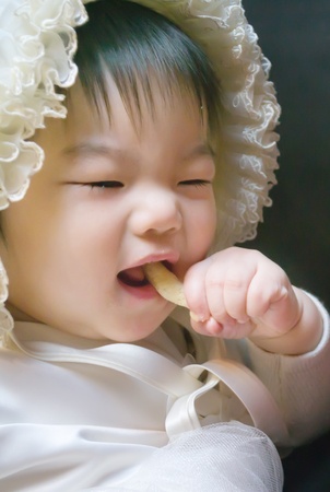 Cute little asian girl eating snackの写真素材