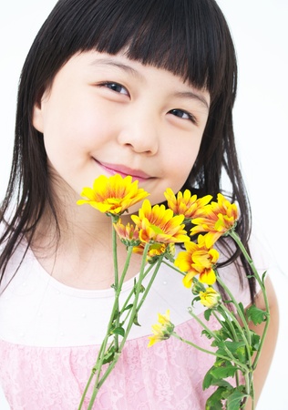 Happy little asian girl with yellow daisyの写真素材