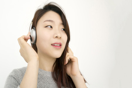 Beautiful asian woman with headphones listening musicの写真素材