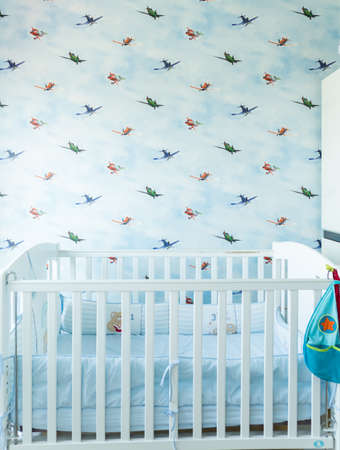 Kid's bedroom decorated in blue theme with airplanes wallpaper in the backgroundの写真素材