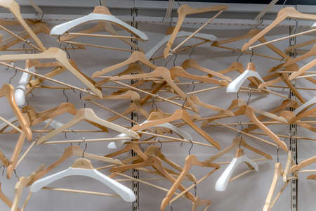 Empty wardrobe, closet full of white and wood hangersの写真素材