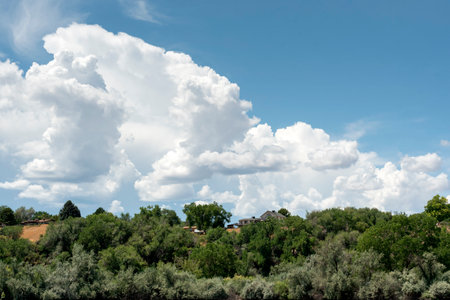 Clouds in the blue sky over green hills. Summer landscape in western Colorado.の写真素材