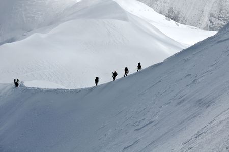 View of group hiking on slope of high Alps mountains.の写真素材
