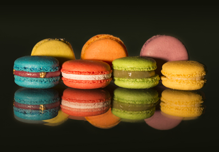 View of colorful macaroons and their reflections on black backgroundの写真素材