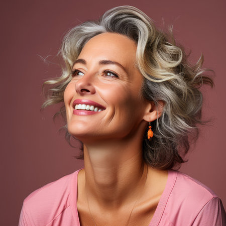 A lighthearted and joyful woman in her 40s with twinkling eyes and a quirky smile against a pink pastel backdrop.の素材
