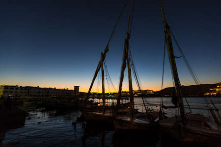 Silhouettes of sailboats moored on the Nile pier in Aswan, Egypt, Africaの写真素材