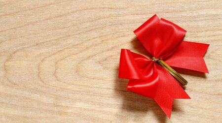Christmas Greeting with a red Ribbon Bow on wooden backgroundの写真素材