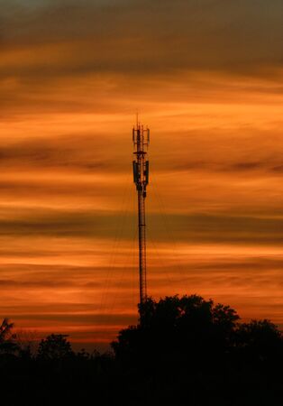 antenna tower with orange sunset skyの写真素材