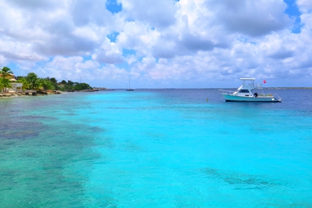Azure cyan calm tropical sea with beautiful pebble shore and scuba diving ship.の写真素材