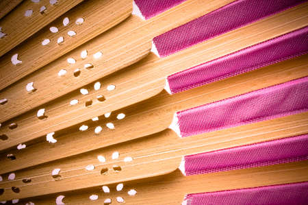 Close-up of a pink wooden hand made fan on white.の写真素材