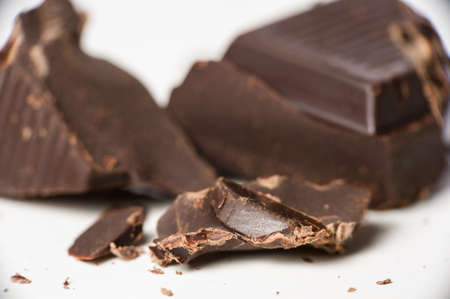 Macro shot of dark chocolate pieces on white.の写真素材