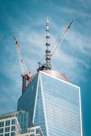 Top of cloudy Freedom tower with crane