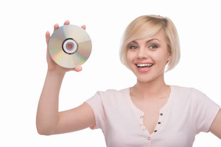 Woman with CD disk. Beautiful young blond hair woman holding CD disk and smiling while isolated on whiteの写真素材