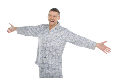 Man in pajamas. Happy young man in pajamas with outstretched hands isolated on whiteの写真素材