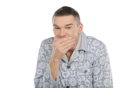 Funny man in pajamas. Cheerful young man in pajamas laughing while isolated on whiteの写真素材