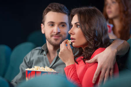 Couple at the cinema. Beautiful young couple watching movie at the cinemaの写真素材