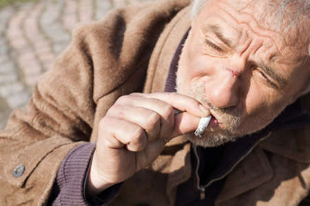 Tramp. Top view of depressed senior man smoking