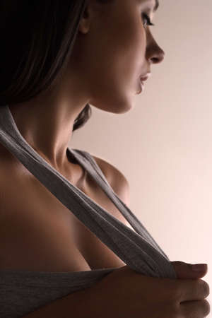 Beautiful woman. Beautiful young girl in stretching out her T-Shirt and looking awayの写真素材