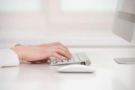 Working on the computer. Close-up of woman typing something on computerの写真素材