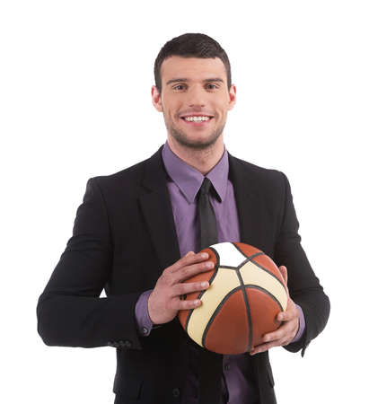 Playful businessman. Confident young man in formalwear holding basketball ball and smiling while isolated on whiteの写真素材