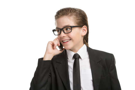 Little businessman on the phone. Cheerful little boy in formalwear talking on the phone and smiling while isolated on whiteの写真素材