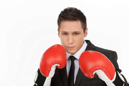 Business fighter. Confident young men in red boxing gloves looking at camera while standing isolated on whiteの写真素材