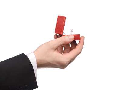 Human hand holding a gift box with engagement ring inside on white backgroundの写真素材