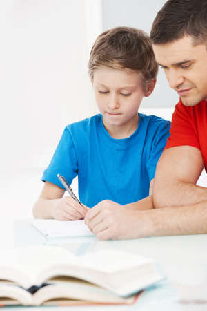 Father and son. Father helping his son with homeworkの写真素材