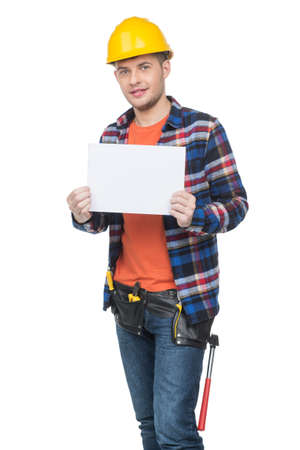 Handyman. Confident young handymen in hardhat holding poster while standing isolated on whiteの写真素材