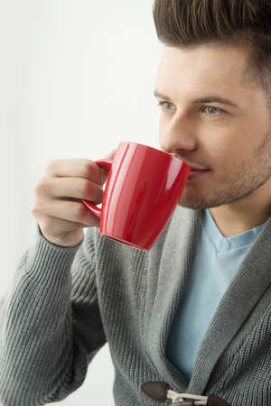 Men drinking coffee. Handsome  young men drinking coffee and looking awayの写真素材