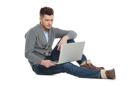 Men surfing web. Handsome young men using computer while sitting isolated on whiteの写真素材