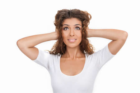 I canï¿½ hear anything. Beautiful young women standing with her hands closing ears while isolated...